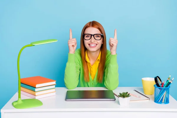 Fotografie krásné zrzavé vlasy mladá studentka bod nahoru nosit brýle svetr práce doma izolované na modrém pozadí — Stock fotografie