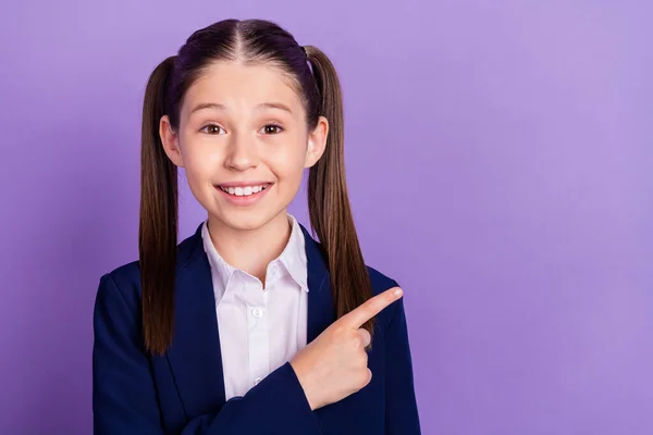 Foto de estudante bonito brilhante vestido azul uniforme sorrindo apontando dedo vazio espaço isolado cor violeta fundo — Fotografia de Stock