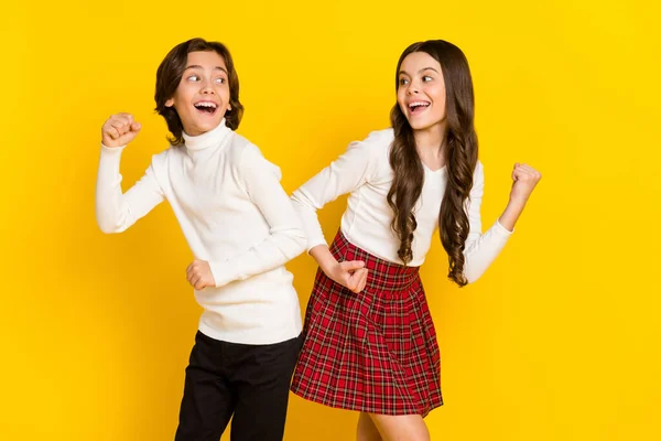 Foto retrato de crianças pequenas sorrindo gestos como vencedores isolados em fundo de cor amarelo brilhante — Fotografia de Stock