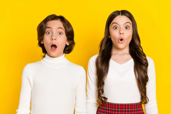 Retrato fotográfico de niños asombrados mirando con la boca abierta aislada sobre un fondo de color amarillo vivo —  Fotos de Stock