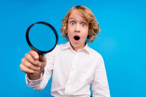 Πορτρέτο της ελκυστική κατάπληκτος αγόρι χρησιμοποιώντας loupe γυαλί βρείτε λύση αναζήτησης που απομονώνονται σε φωτεινό μπλε χρώμα φόντο — Φωτογραφία Αρχείου