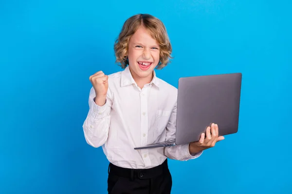 Portret atrakcyjnego szczęśliwego chłopca korzystającego z laptopa radującego się sukcesem odizolowanym od jasnoniebieskiego tła — Zdjęcie stockowe