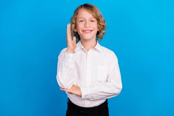 Retrato de menino alegre atraente subindo mão assistir lição isolada sobre fundo de cor azul brilhante — Fotografia de Stock