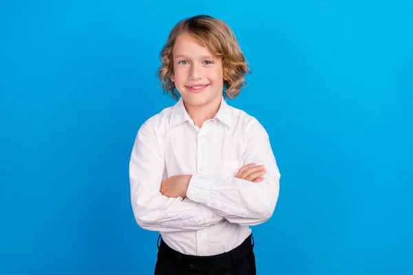 Retrato de conteúdo atraente menino alegre braços dobrados vestindo camisa branca formal isolado sobre fundo de cor azul brilhante — Fotografia de Stock