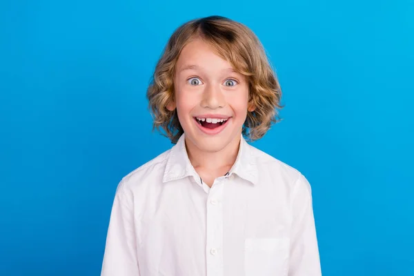 Retrato de atraente surpreendido alegre menino grande notícia reação isolada sobre vibrante azul cor de fundo — Fotografia de Stock