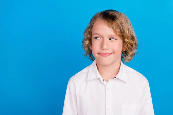 Retrato de atraente menino alegre curioso olhando para o lado cópia espaço vazio isolado sobre vibrante fundo de cor azul — Fotografia de Stock