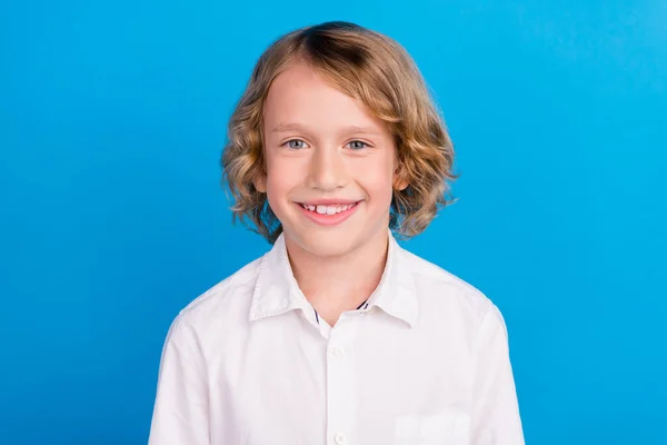 Retrato de conteúdo atraente menino alegre vestindo camisa branca isolada sobre fundo de cor azul vibrante — Fotografia de Stock