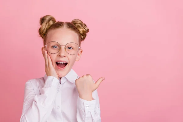 Foto von beeindruckt kleine Mädchen Punkt leeren Raum tragen weißes Hemd Brille isoliert auf pastellrosa Hintergrund — Stockfoto