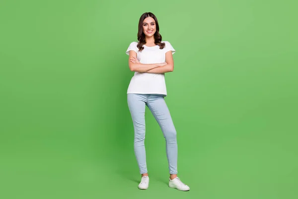 Full body foto di cool bruna giovane donna braccia incrociate indossare jeans t-shirt isolato su sfondo di colore verde — Foto Stock