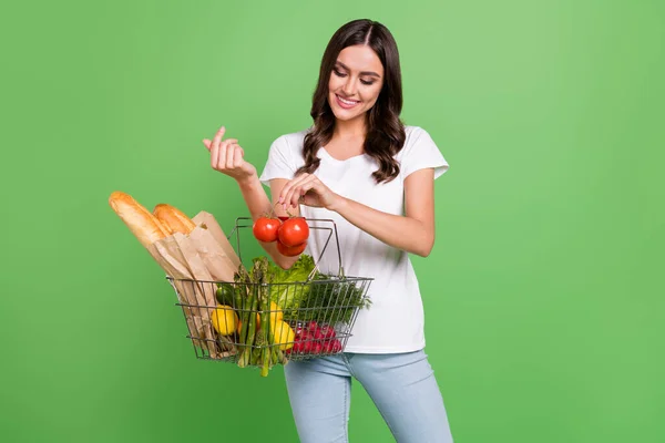 Foto van mooie brunette jonge dame doen winkelen dragen t-shirt jeans geïsoleerd op groene kleur achtergrond — Stockfoto