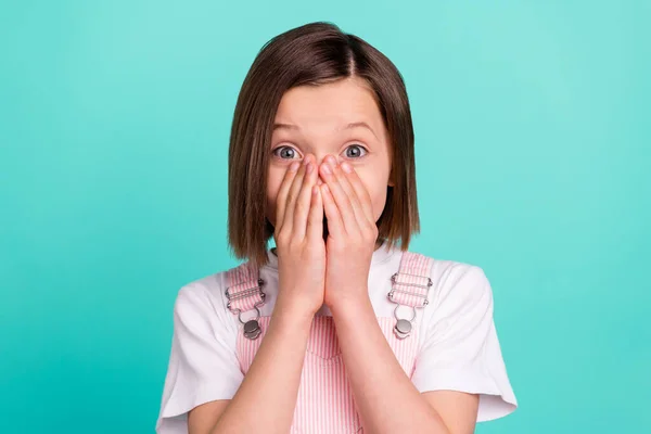 Foto van gelukkig verbaasd geschokt klein meisje houd handen cover gezicht mond geïsoleerd op teal kleur achtergrond — Stockfoto