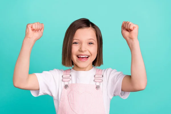Foto de alegre feliz positivo menina bom humor levantar punhos vencedor isolado no fundo cor pastel teal — Fotografia de Stock