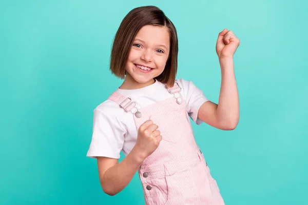 Zdjęcie szczęśliwy uroczy mały zwycięzca dziewczyna podnieść pięści uśmiech odizolowany na pastelowym tle teal kolor — Zdjęcie stockowe