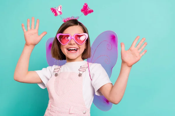 Foto van grappige charmante schoolmeisje gekleed roze algemene vleugels dansen op zoek lege ruimte geïsoleerde turquoise kleur achtergrond — Stockfoto