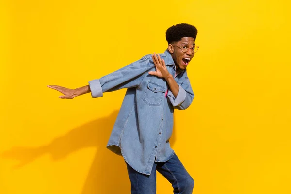 Foto av funky ung afro amerikan glad man dans gott humör leende isolerad på gul färg bakgrund — Stockfoto