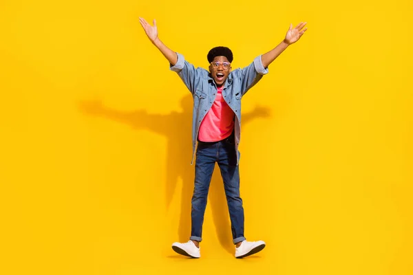 Foto de tamaño completo de hombre de piel oscura joven asombrado levantar las manos buen humor sorprendido aislado en el fondo de color amarillo — Foto de Stock