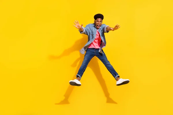 Foto de comprimento total de feliz afro americano jovem salto até humor louco isolado no fundo de cor amarela — Fotografia de Stock