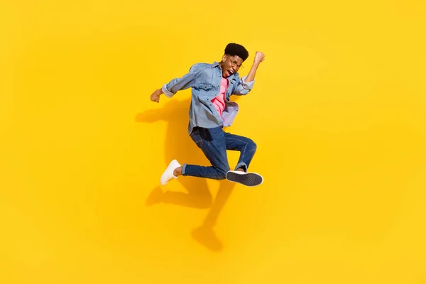 Foto de tamaño completo de feliz joven afro americano alegre saltar ganador aislado sobre fondo de color amarillo — Foto de Stock