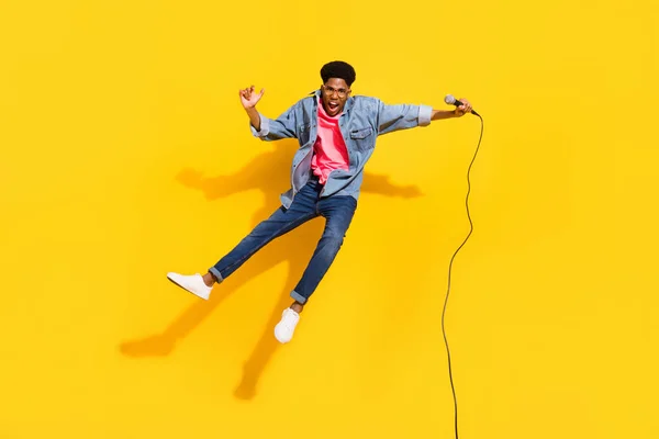 全长照片中快乐的非洲裔美国年轻人跳起来歌手欣赏黄色背景的音乐 — 图库照片