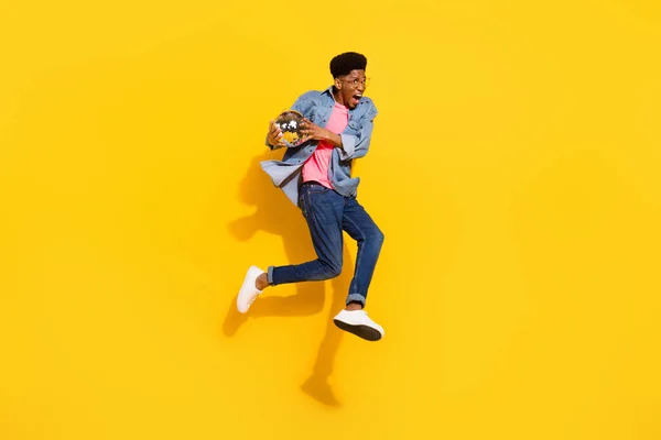 Full size photo happy cheerful dark skin man jump up hold disco ball enjoy isolated on yellow color background — Stock Photo, Image