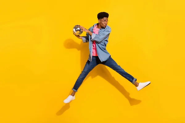 Foto em tamanho completo de homem de pele escura feliz usar camisa de ganga segurar salto de bola disco enviar beijo de ar isolado no fundo de cor amarela — Fotografia de Stock