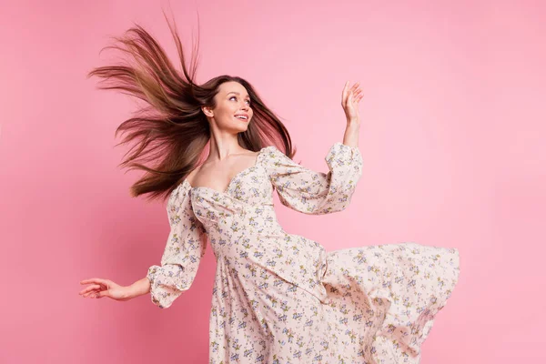 Photo portrait jolie fille portant une robe florale marchant par temps venteux vol cheveux regardant copyspace isolé couleur rose pastel fond — Photo