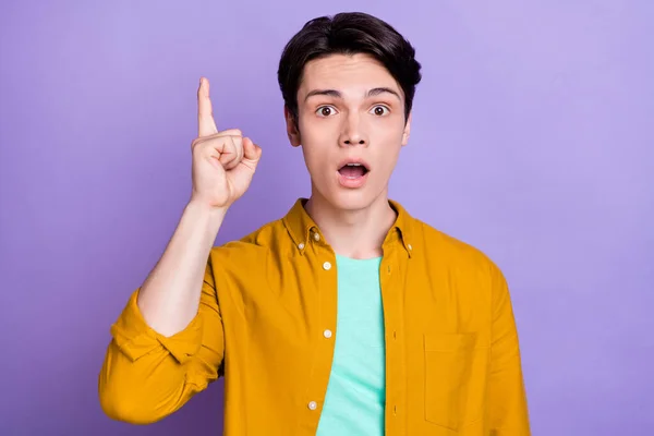 Foto von beeindruckt Brunet Millennial Kerl Punkt oben tragen gelbes Hemd isoliert auf violettem Hintergrund — Stockfoto