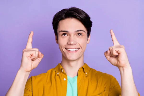 Foto van coole brunet jonge man punt omhoog te kijken dragen geel shirt geïsoleerd op violette kleur achtergrond — Stockfoto