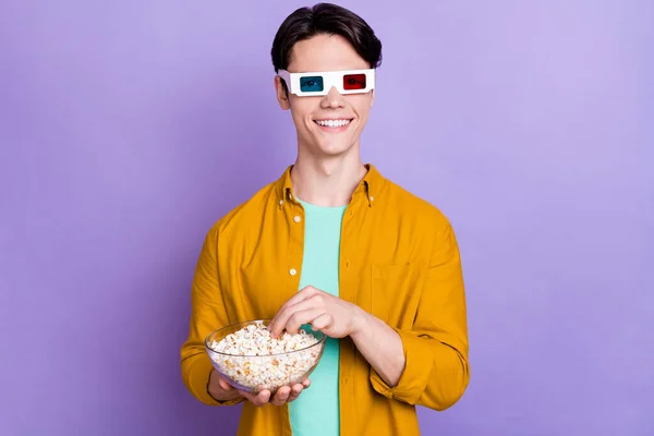 Foto von jungen Mann glücklich positives Lächeln sehen Film tragen 3D-Brille essen Popcorn isoliert über violetten Farbhintergrund — Stockfoto