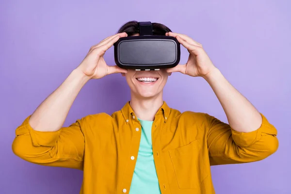 Zdjęcie młodego człowieka szczęśliwy pozytywny uśmiech ręce dotknąć wirtualnej rzeczywistości okulary vr gra izolowana na fioletowym tle koloru — Zdjęcie stockowe