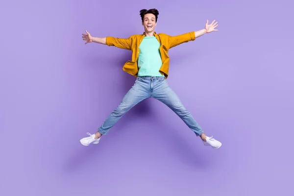 Helkroppsfoto av ung man glad positiv leende har kul hoppa upp isolerad över violett färg bakgrund — Stockfoto