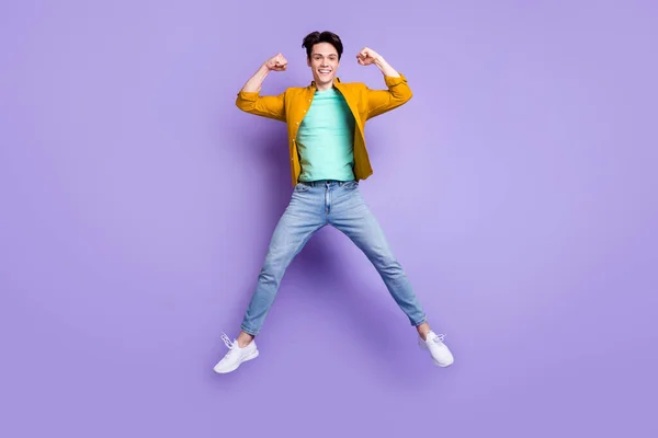 フル長さ写真の若い男幸せな正の笑顔ジャンプショー手筋肉絶縁上紫色の背景 — ストック写真