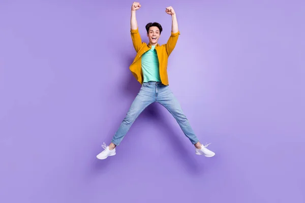 Pleine photo du corps de hourra brunet jeune homme saut porter chemise jeans isolé sur fond de couleur violette — Photo