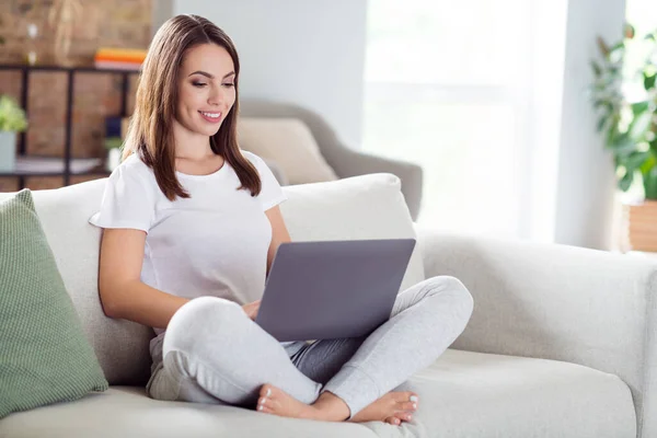 Foto porträtt brunett kvinna sitter på soffan hemma arbetar på laptop distans medan karantän — Stockfoto