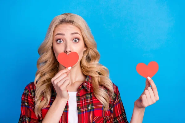 Foto de doce impressionado jovem mulher vestida camisa xadrez vermelho coração tampa lábios grandes olhos isolado azul cor fundo — Fotografia de Stock