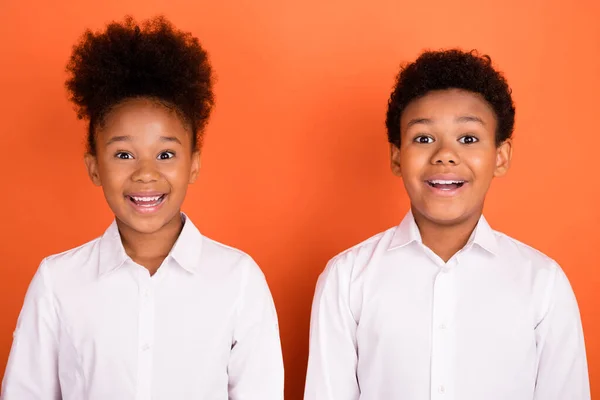 İki genç siyahi çocuğun fotoğrafı, turuncu arkaplandan izole edilmiş her türlü sahte yenilik karşısında hayrete düştü. — Stok fotoğraf