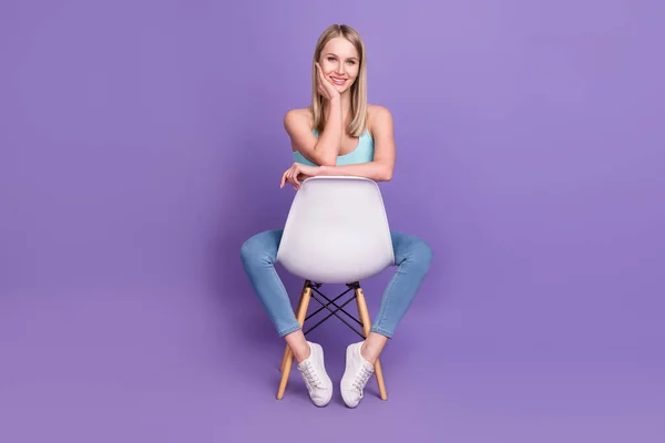 Volledige lengte body size foto blonde vrouw in casual kleding zitten op stoel geïsoleerde pastel violet kleur achtergrond — Stockfoto
