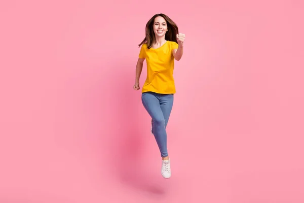 Foto em tamanho completo de fresco morena millennial senhora executar desgaste rosa camisola jeans tênis isolado no fundo rosa — Fotografia de Stock