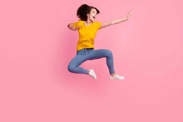 Foto di impressionato divertente giovane donna vestita di giallo t-shirt salto alto praticare yoga isolato colore rosa sfondo — Foto Stock