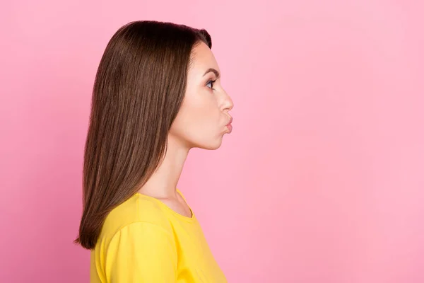 Flört eden esmer kadının profil fotoğrafı. Milenyum güzeli boş uzayı öpen kadın. Pembe arka planda izole edilmiş sarı tişört giy. — Stok fotoğraf