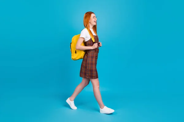 Ganzes Profil Seite Foto von jungen Mädchen glücklich positives Lächeln gehen Schritt Universitätsausbildung isoliert über blauen Farbhintergrund — Stockfoto