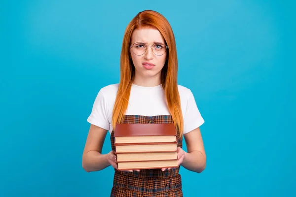 Porträt von attraktiven irritierten Nerd-Mädchen hält Haufen Buch Materialien Wissenschaft isoliert über helle blaue Farbe Hintergrund — Stockfoto