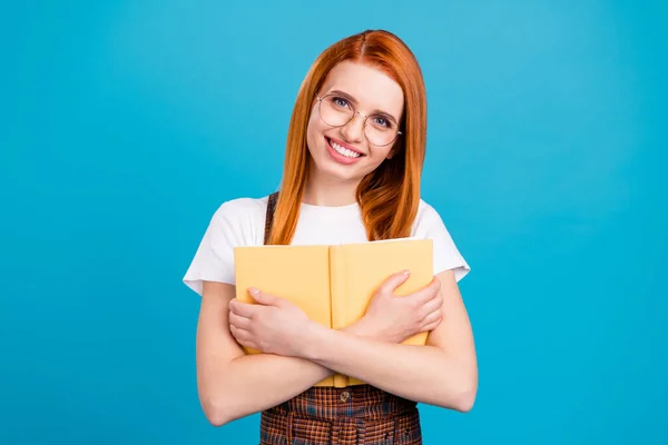 Foto von jungen Schulmädchen glücklich positives Lächeln Umarmung Schmusebuch Bildung isoliert über blauem Hintergrund — Stockfoto