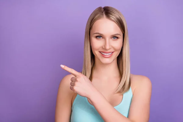 Foto de la señora milenaria rubia optimista punto vacío espacio desgaste top azul aislado sobre fondo de color violeta —  Fotos de Stock