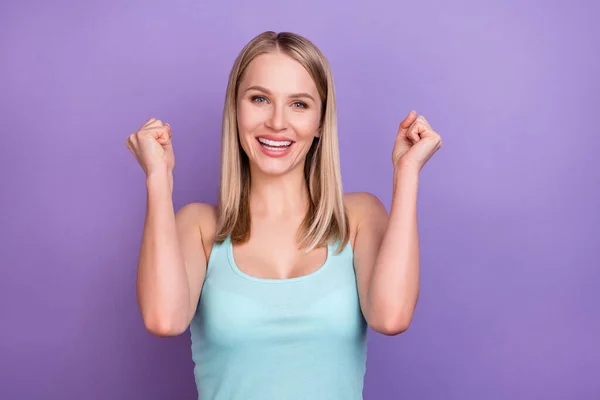 Foto de hooray rubia milenaria dama manos puños usan top azul aislado sobre fondo de color violeta —  Fotos de Stock