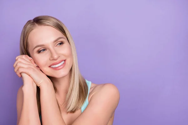 Foto van schattige blonde jonge dame handen hoofd kijken lege ruimte dragen blauwe top geïsoleerd op violette kleur achtergrond — Stockfoto