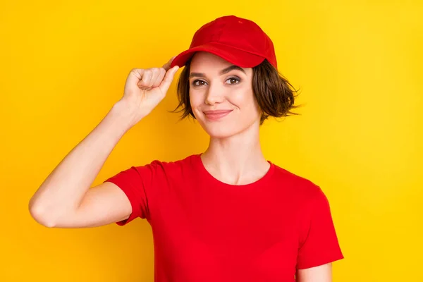 Foto de dulce bonita joven cartero vestido rojo uniforme brazo headwear sonriente aislado color amarillo fondo — Foto de Stock