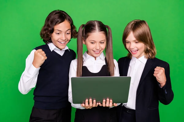 Portret van drie trendy vrienden vriendschap vrolijke kinderen met behulp van laptop plezier geïsoleerd over helder groene kleur achtergrond — Stockfoto