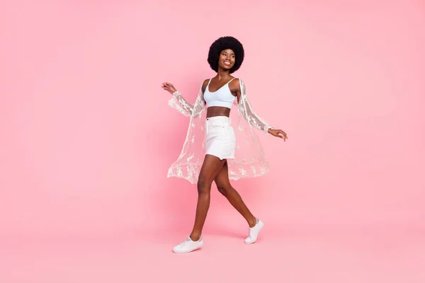 Full size photo of cheerful afro american young woman walk look empty space isolated on pink color background — Foto de Stock