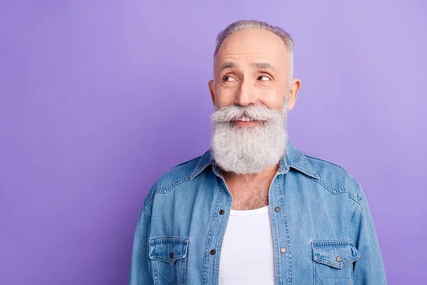 Photo of attractive sweet age gentleman wear jeans shirt smiling looking empty space isolated violet color background — Φωτογραφία Αρχείου